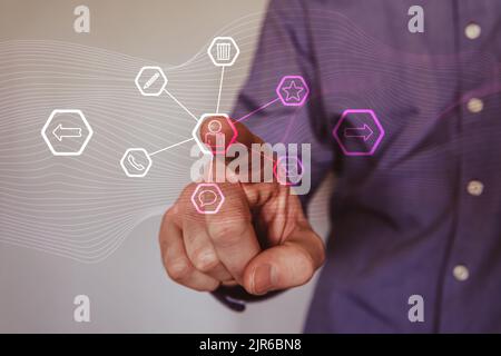 Man pressing with his finger on the contact icons of a virtual screen Stock Photo
