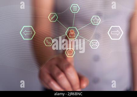 Woman pressing with her finger on the contact icons of a virtual screen Stock Photo