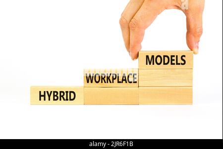 Hybrid workplace models symbol. Concept words Hybrid workplace models on wooden blocks. Businessman hand. Beautiful white background. Business hybrid Stock Photo