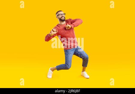 Happy handsome young man in casual outfit dancing and having fun in fashion studio Stock Photo