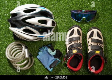 Flat lay composition with different cycling accessories on green grass background. Concept of sport lifestyle. Stock Photo