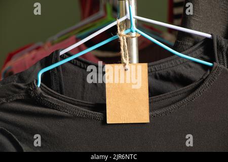 cardboard, packaging, casual, clothing, branding, shopping, brown paper price tag weighs on clothes on a rack on a hanger in the sales area, blank pri Stock Photo