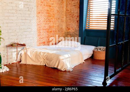 mattress on the floor near the window, bed in the bedroom, bedroom interior in the apartment, stylish bedroom Stock Photo