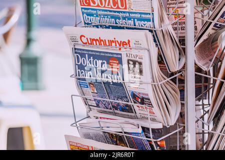 07 July 2022, Antalya, Turkey: Cumhuriyet newspaper and other press media on a rack at city street. Turkish news and journalism Stock Photo