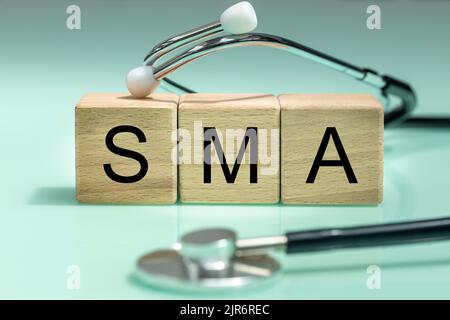 SMA, spinal muscular atrophy, Written on wooden blocks, a rare disease in which, due to a genetic defect, neurons in the spinal cord responsible for m Stock Photo