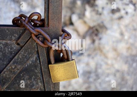 old rusty metal door with chain and brass padlock Stock Photo