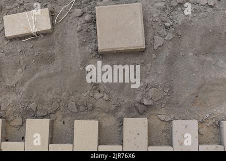Pavement repair and laying of paving slabs on the walkway, stacked tile cubes on the background. Laying paving slabs in the pedestrian zone of the Stock Photo