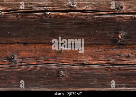 Macro shot of an ancient weathered dark brown cracked wood beam surface with nice rough grain texture. Stock Photo