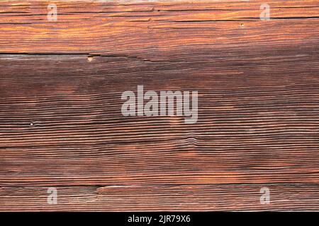 Macro shot of an ancient weathered dark brown cracked wood beam surface with nice rough grain texture. Stock Photo