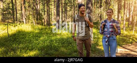 man and woman with backpacks on a forest walk on sunny summer day. outdoor adventure. banner with copy space Stock Photo