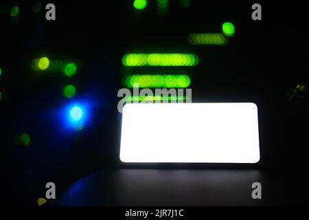An empty form with a background on the phone screen, copy space. Smartphone on the background of a dark server room, mockup Stock Photo