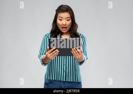 surprised asian woman using tablet computer Stock Photo