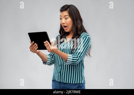 shocked asian woman using tablet computer Stock Photo