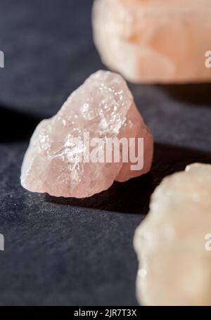 raw rose quartz crystals on black slate background Stock Photo