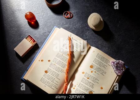 magic book, wax candle, matches and gem stones Stock Photo