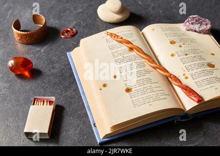 magic book, wax candle, matches and gem stones Stock Photo