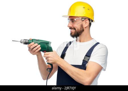 happy male worker or builder in helmet with drill Stock Photo