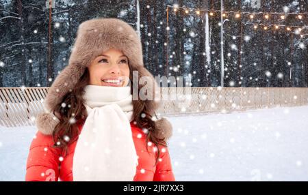 happy woman in winter hat over ice skating rink Stock Photo