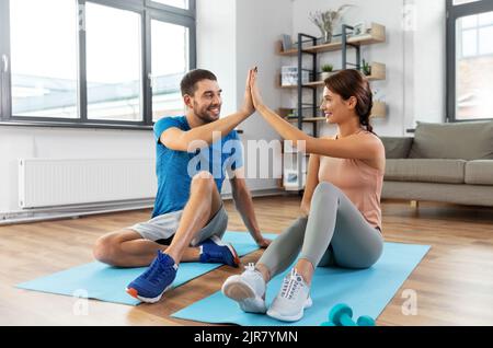couple doing sports and making high five at home Stock Photo