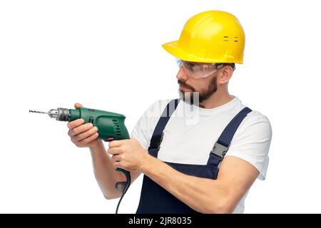 male worker or builder in helmet with drill Stock Photo