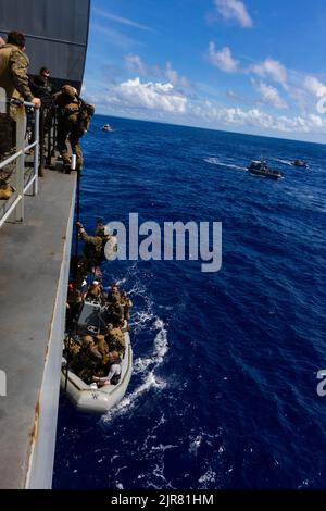 U.S.  Marines, with Battalion Landing Team 2/5, 31st Marine Expeditionary Unit, board Expeditionary Mobile Base USS Miguel Keith (ESB-5) from a rigid hull, inflatable boat during a visit board search and seizure exercise in the Philippine Sea, Aug. 17, 2022. The 31st MEU maintains the capability to seize and clear ships while at sea to protect themselves and allies in the Indo-Pacific Region. The 31st MEU is operating aboard ships of the Tripoli Amphibious Ready Group in the 7th Fleet area of operations to enhance interoperability with allies and partners and serve as a ready response force to Stock Photo