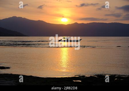 Indonesia Alor Island - Ocean landscape with fishing boat at sunset Stock Photo