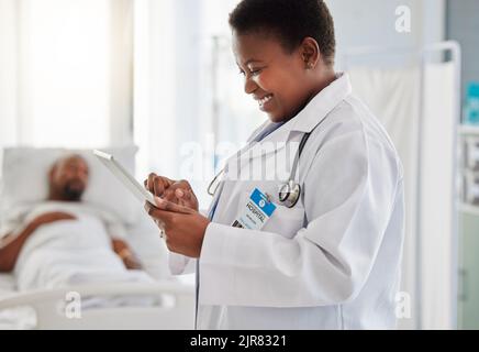 Healthcare, insurance and doctor reading good test results or an exciting email on a digital tablet and feeling positive. Medical worker smiling due Stock Photo