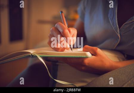 Creative writing at home by female hands enjoying a calm, peaceful day off indoors. Woman making notes in a journal, expressing her feelings and Stock Photo