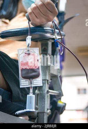 Blood donor in the midst of donating blood, close up shot. Stock Photo