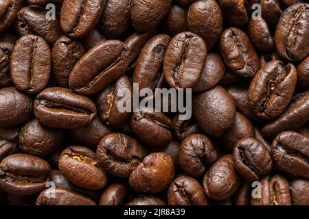 Coffee beans background. Background of roasted coffee beans. A macro photo of fried brown coffee beans on the table. Stock Photo