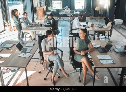 Open office space policy business people having in formal discussion at their desk in a busy, collaboration corporate workplace. Professional employee Stock Photo