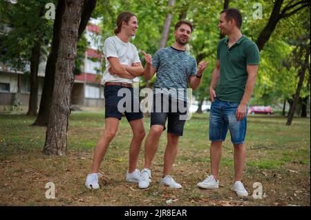 Three handsome young man having fun in a park Stock Photo
