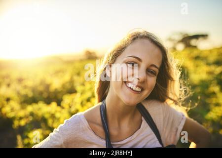 Whats not to love about living on a farm. Portrait of a happy young woman working on a farm. Stock Photo