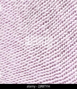 Knitted real woolen cotton fabric light background. Warm light woolen braids are knitted with threads background. Stock Photo