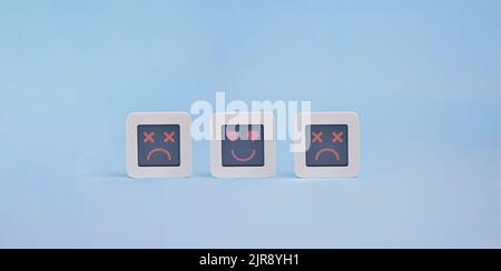 Set of computers with stylized faces of heart eyes and dead faces on lcd display, Customer Experience Concept, a system crash symbol Stock Photo
