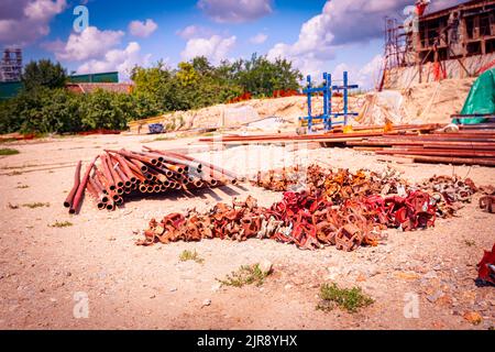 View on heap of disassembled steel scaffolding joint on construction site. Stock Photo