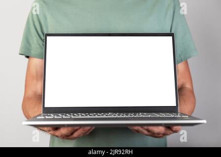 Man holding laptop mockup with empty screen. Male using computer for showing presentation for work, study. Report, new project, startup presenting. High quality photo Stock Photo