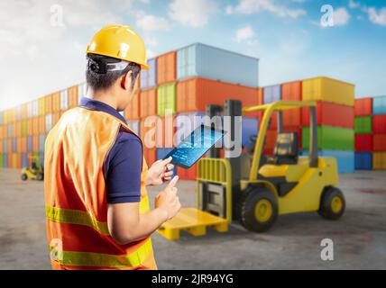 Engineer or asian worker work with tablet at container terminal Stock Photo