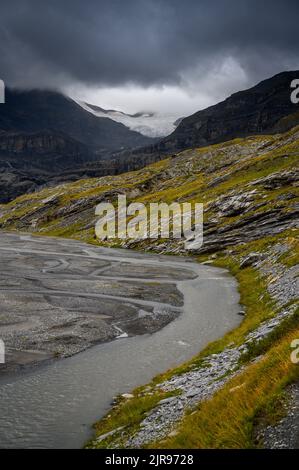 Lämmerenboden with meandering creek and wildstrubel glacier in the distance in valais Stock Photo