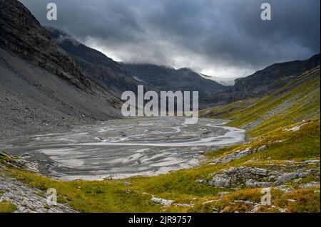 Lämmerenboden with meandering creek and wildstrubel glacier in the distance in valais Stock Photo