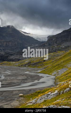 Lämmerenboden with meandering creek and wildstrubel glacier in the distance in valais Stock Photo