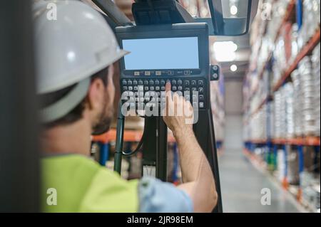 Skilled warehouse worker operating the electric forklift Stock Photo