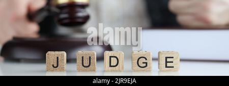 Male judge in courtroom hits with gavel and clenches fist Stock Photo