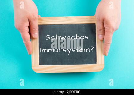 Weak immune system is standing in german language on a chalkboard, healthy eating and lifestyle concept, natural protection from disease Stock Photo