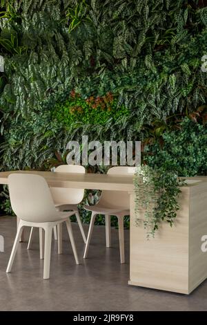 Green living room with chairs and table, vertical garden - stock photo Stock Photo