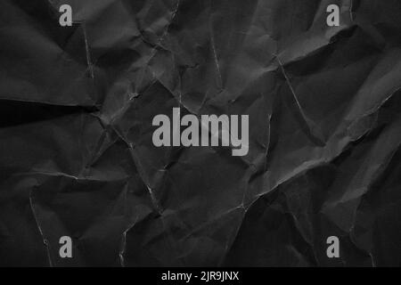 Heavy crumpled black paper texture background Stock Photo