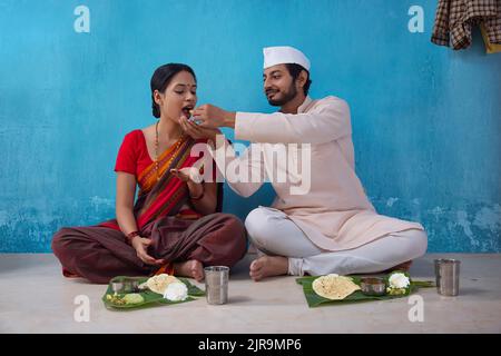 Maharashtrian man feeding his wife during lunch Stock Photo