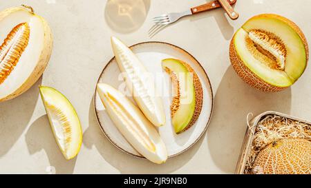 Various sliced melons on a light stone background Stock Photo