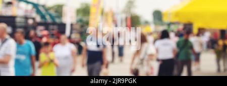 Blurred pedestrian walking down the city street, unrecognizable crowd of people in bokeh for census or citizenship concept, panoramic image Stock Photo