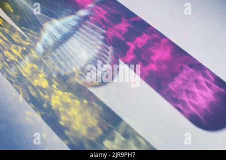 Sunlight through colored glass of water on blue background. Long harsh shadows. Summe vacation concept. Stock Photo